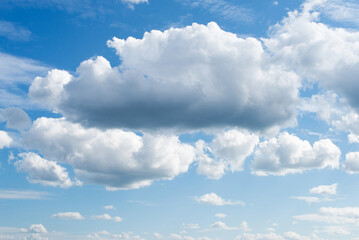 Bright gradient blue sky with fluffy white clouds on a sunny day