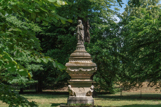Dessau Roslau. Germany. 06.21.2025 Stone statue in antique style among the greenery of the Luisium Park