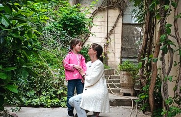 Mother and daughter walking together outside . High quality photo