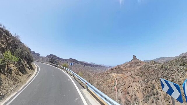Gran Canaria, Spain &ndash; 360 camera footage simulating drone flight from moving car on GC-60 mountain road through volcanic terrain, Canary Islands. Lens flare.