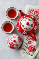 Red porcelain tea set with floral pattern serving black tea