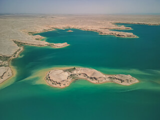 Aerial view of Kuimazar Reservoir shoreline and peninsula in Uzbekistan. Turquoise water meets the...