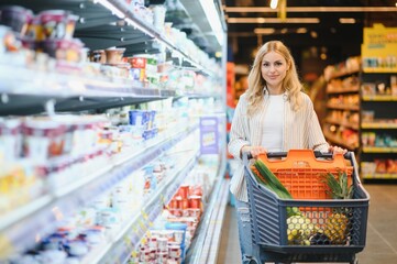 Young woman looking at product at grocery store. Costumer buying food at the market