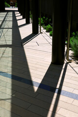 Glass-roofed colonnade corridor of a commercial building in the summer sunshine