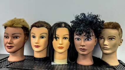 Obraz premium Mannequins lining a shelf at a barbering school make for a eerie tableau