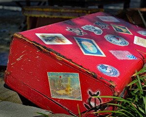 A battered suitcase lies along a flooded road