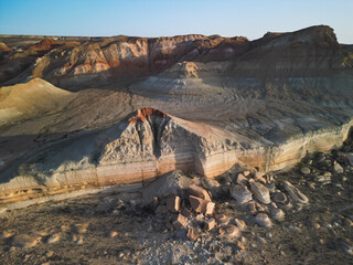 Sunlight bathes the sandstone butte and colored cliffs of Aktumsuk cape, highlighting subtle...