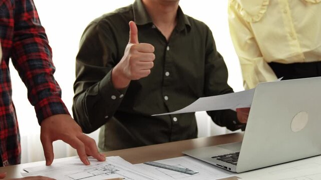 Safety engineer praising skilled architect success design building blueprint project on laptop with architectural document and measurement tool scatter around at modern office. Closeup. Delineation.