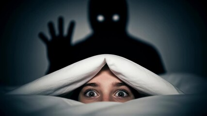 Woman terrified in bed, hiding from monster shadow. Nightmare, fear, horror, and sleep paralysis concept footage. - Powered by Adobe