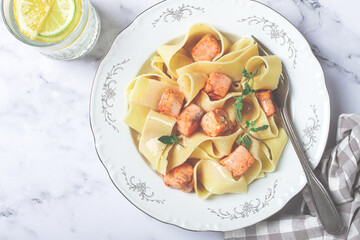 tagliatelli pasta, with salmon slices and herbs, on a decorative plate, homemade, no people