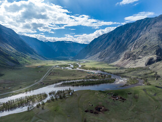 Summer landscape in the Chulyshman mountain valley. Winding mountain river, green alpine meadows and beautiful mountains.