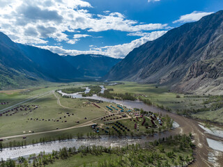Summer landscape in the Chulyshman mountain valley. Winding mountain river, green alpine meadows and beautiful mountains.