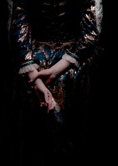 A person in a historical dress with their hands crossed in front of them.