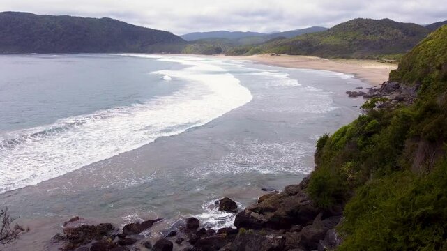 Drone shot of pristine Rada Ranu beach with crashing waves and dense green forest in southern Chile &ndash; Pacific coastline and natural wilderness