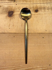 Golden spoon on a rustic wooden table