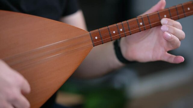 Authentic Turkish instrument performance &ndash; saz close-up from seated musician