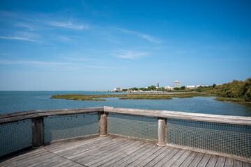 Obraz premium Panoramic view of the Belvedere wooden pier in Lignano Sabbiadoro, overlooking the lagoon.
