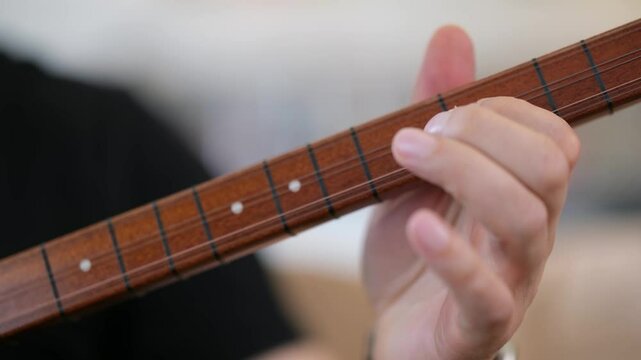 Man playing saz solo indoors &ndash; hand movement and instrument detail