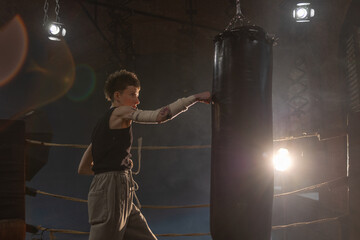 Boxing with a punching bag, sports achievements concept, female wrestler in a boxing ring,...