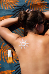 Skin and Body Care.  Woman Applying Sunscreen on Tanned Shoulder in Form of the Sun. Sun...
