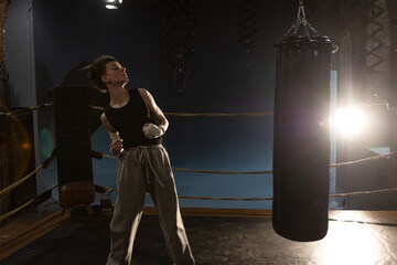 Woman boxer in ring with cinematic lighting, throwing powerful punch during intense training
