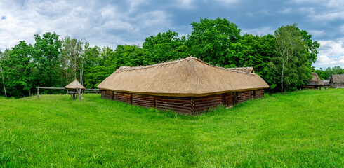 A typical Ukrainian ancient house covered with straw stands quietly, reflecting traditional rural...