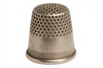 Metal thimble featuring circular indentations, protecting fingers during sewing, resting against transparent backdrop