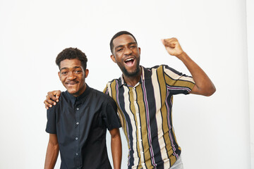Joyful African American men celebrating together, showcasing their happiness and camaraderie. The...