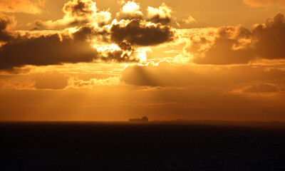 Sailing into hazy orange sunrise