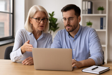 Obraz premium Business colleagues review project on laptop collaborating on a strategy professional teamwork office setting