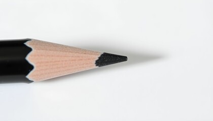 Fototapeta premium Close-up view of a sharpened black pencil tip against a white background.