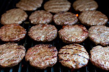Overhead View: Beef Burgers Arranged on Grill Grate, Juicy Beef Burgers on Flaming Grill – Close-Up Shot