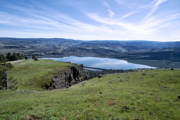 View of a massive Columbia River winding through the Columbia River Gorge. The gorge slopes are...