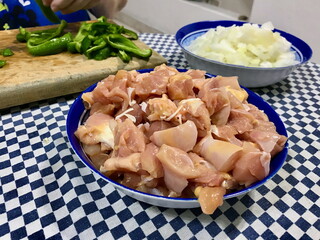 Raw Chicken Pieces in Blue Plastic Bowl