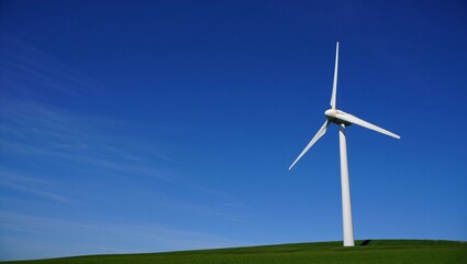 Single white wind turbine generating renewable energy on a green grassy hill under a clear blue sky. Symbolizing clean energy, sustainability, eco-friendly power sources.