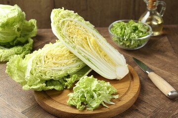 Fresh cut Chinese cabbage and knife on wooden table