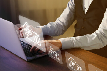 Real estate agent looking for housing via laptop at wooden table, closeup. Illustrations of...