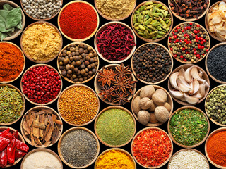 Set of different aromatic spices in bowls on black background, flat lay