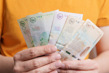 Hands holding new colombian banknotes spread out like a fan