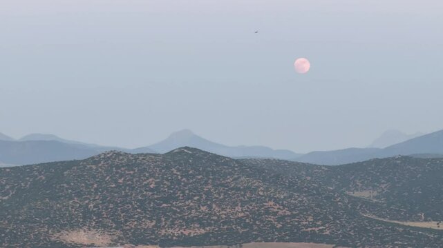 City in the mountains under a full moon. Strawberry moon. Turkiye, Korkuteli. 