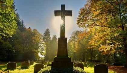 a tall stone cross stands solemnly in a quiet cemetery surrounded by towering trees as sunlight filters through the leaves casting gentle rays over the scene