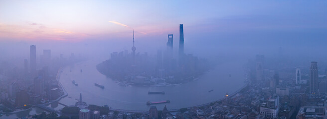 Aerial view of Shanghai skyline with heavy fog at sunrise.