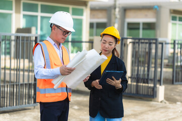 Two Asian male and female engineers inspecting work Two female architects are working and...