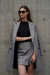 A stylish woman poses confidently, exuding elegance in a tailored ensemble. The image captures her sophisticated aura and refined fashion sense