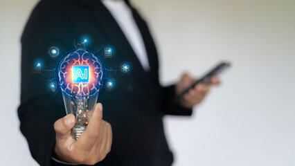 Businessman holding a lightbulb with an artificial intelligence (AI) icon and digital innovation...