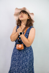 Beautiful young asian woman wearing blue summer dress and beach straw hat is suffering sore throat...