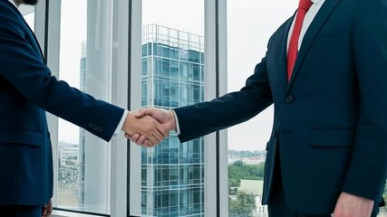 Business people shake hands in front of a city office building window - Powered by Adobe