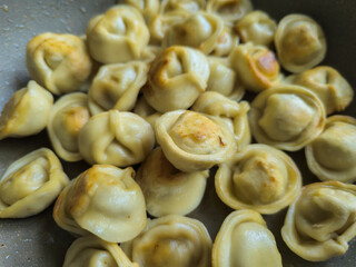 Dumplings frying in warm kitchen during daytime