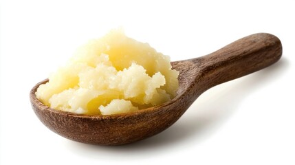A wooden spoon with a yellow substance on it, possibly ghee or butter, against a white background.