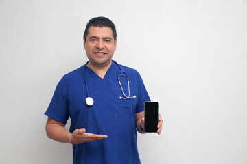 Dark-skinned Latino male doctor with a stethoscope shows his cell phone to have online...
